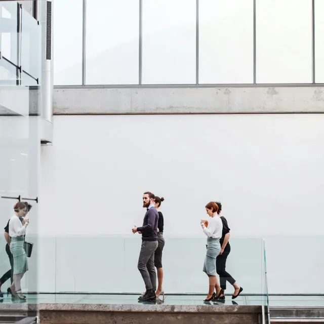 Medarbejdere ved glasfacade
